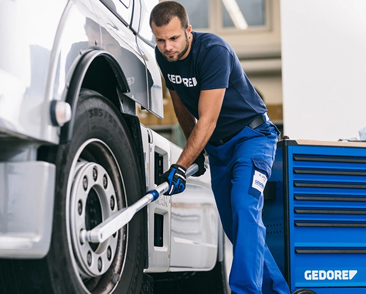 Mechanic tightening a wheel fastener on a truck with a GEDORE tool