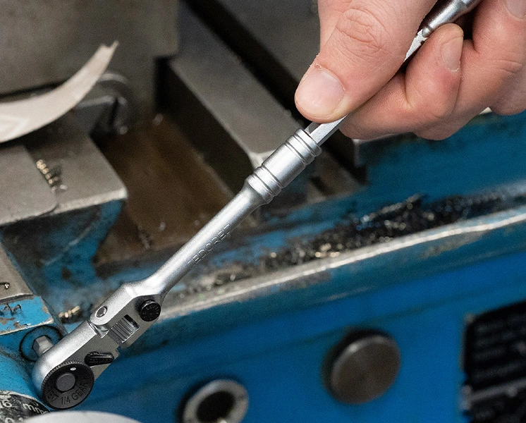 Mechaniker bei Arbeiten unter einem angehobenen Fahrzeug