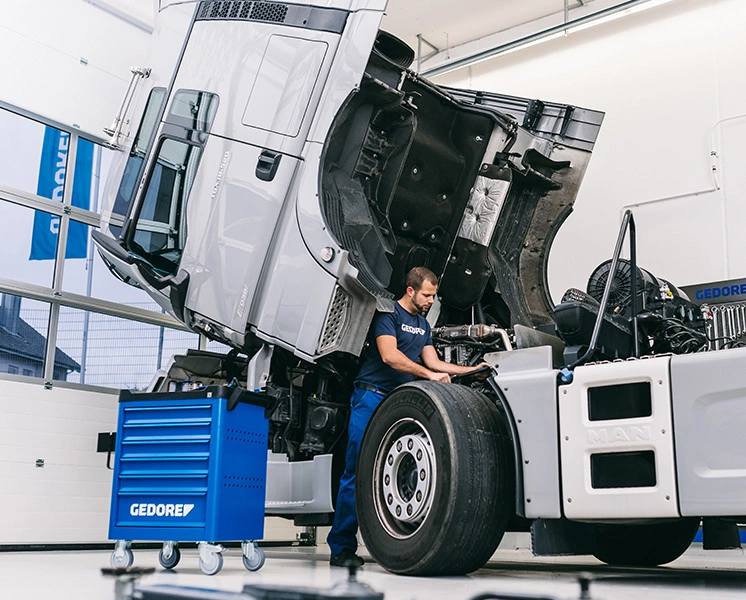 Mechanic performing maintenance on a truck with a GEDORE tool trolley